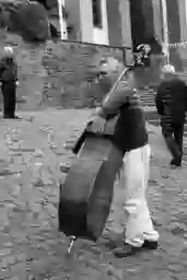 'Image of the musican 'Mohamed Bidaoui' carrying his big double bass' in a higher resolution